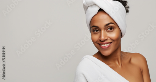 Studio portrait of happy and attractive young black woman with natural clean skin and cotton bath towel
