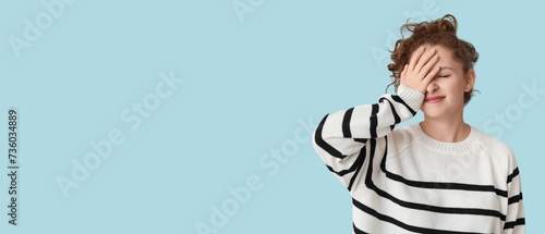 Young woman doing facepalm on light blue background with space for text