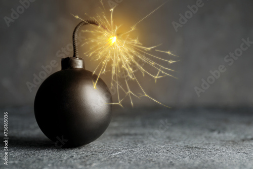 Old fashioned black bomb with lit fuse on grey table, space for text