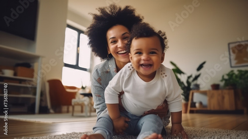 childhood, kids and people concept - happy african american mother and her baby son playing with toy car together on sofa at home