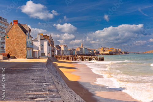Sunny promenade and beach of beautiful walled port city of Saint-Malo at high tide, Brittany, France