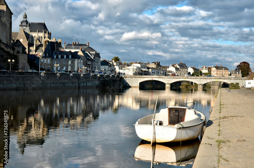 Mayenne river in the town of the same name with Notre-Dame basilica and a little boat, commune in the Mayenne department in north-western France