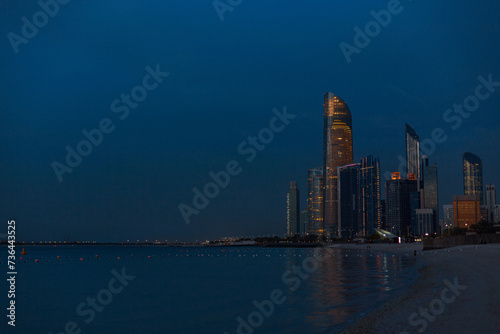 Evening beach overlooking the metropolis of Abu Dhabi, UAE. Twilight and modern buildings