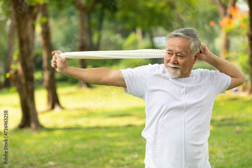 asian senior man workout and stretching with white towel in the park