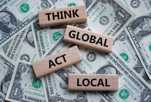 Think global act local symbol. Wooden blocks with words Think global act local. Beautiful dollar background. Business and Think global act local concept. Copy space.