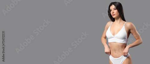 Young woman in white cotton underwear on grey background with space for text