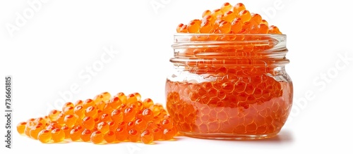 Glass jar containing tasty red caviar against white backdrop