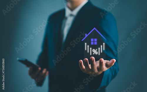 Real estate investment concept. Person holding house and up arrow icon on virtual screen for analyzing mortgage loan home and insurance real property mortgage. interest rate, Investment planning..
