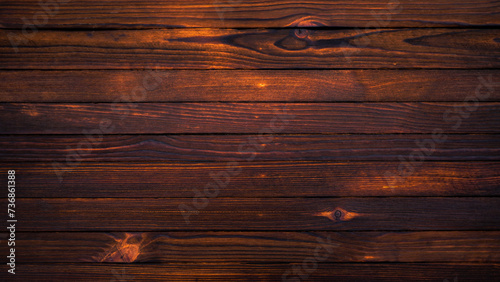 Burnt wooden background made of slats. A gloomy wooden surface with cracks. The texture of the tree.