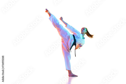 Master of Kung Fu, fighter show high kick pose in neon light, filter against over white background. Concept of sport, recreation, art, hobby, culture. Copy space for ad, text.