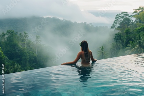 Tranquil Retreat: Young Woman Swimming in Resort Pool Overlooking Lush Mountain Vistas