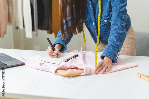 Young small business woman prepare used clothes to sell on internet.