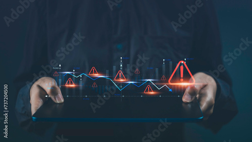 Business economy crisis and investment risks. Tablet show virtual stock graph data fall with alert warning sign for caution finance investing economic recession situation warning.