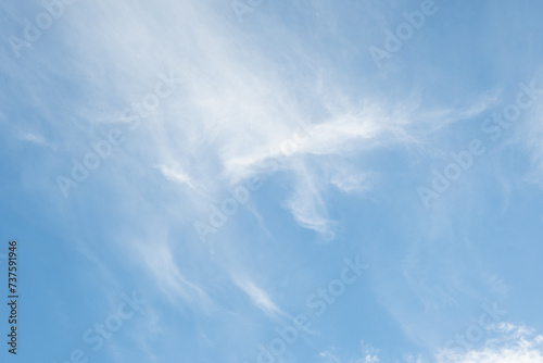 Light ethereal white clouds high in a sunny blue sky, as a nature background 