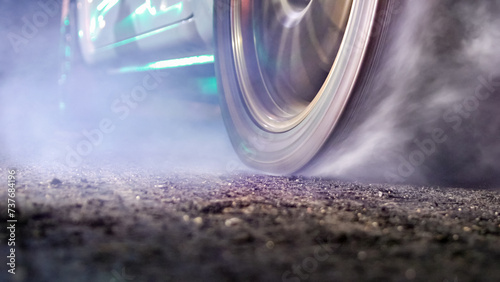 EV Drag racing car is burning tires at start line.