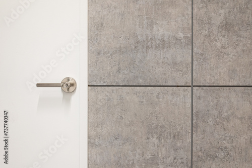 door handle on white door. metal door knob on modern interior. Shiny silver door handle. Concept of interior details. Copy space.