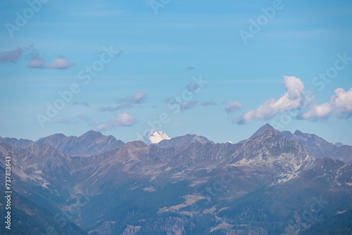 Panoramic view of Grossglockner seen from mountain Goldeck, Latschur group, Gailtal Alps, Carinthia, Austria. Scenic hiking trail along idyllic alpine meadow in Austrian Alps. Wanderlust in summer
