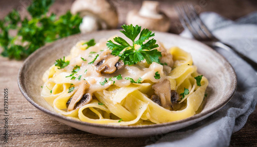 Tagiatelle with porcini mushroom cream sauce on a wooden table, parsley decorated