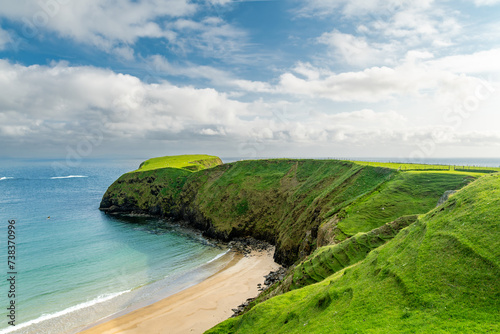 Sheep grazing near Silver Strand, a sandy beach in a sheltered, horseshoe-shaped bay, situated at Malin Beg, near Glencolmcille, in south-west County Donegal, Ireland