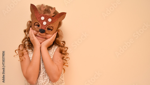 Unique child. Happy child in deer costume. Little cute girl in a carnival masquerade deer mask made of foamiran. The child is preparing to celebrate festival.