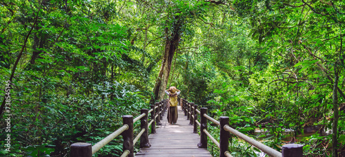 The Girl walking in the bridge and enjoying the tourism in through the mangrove forest. Waterfall Than Bok Khorani Nature Trail. Krabi, relax, travel, backpack, nature, Tourism, countryside.