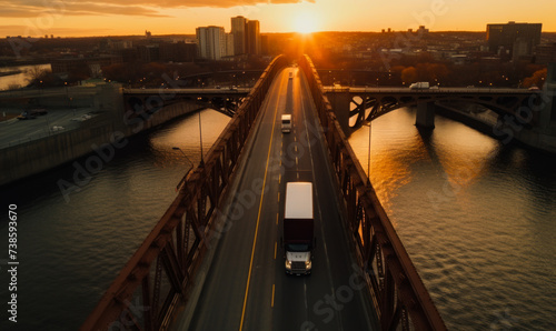 Semi trucks driving across bridge at sunset