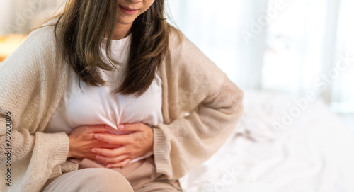 Woman sick unhappy holding belly stomach with suffering from stomach ache pain, monthly period, gastritis, gastroenteritis, food poisoning, diarrhea, intestinal inflammation, Woman healthcare.