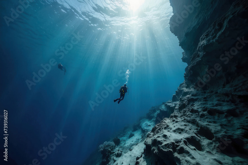 scuba diver at the edge of a drop-off, endless deep blue abyss, feeling of awe and solitude