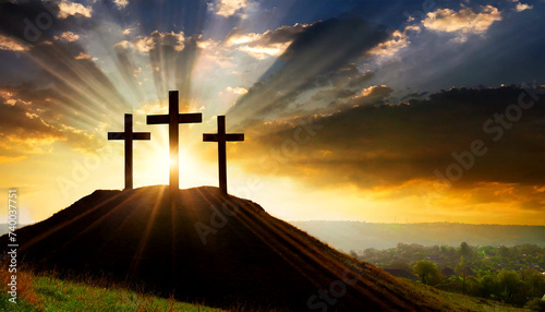 Silhouette of three wooden religious crosses above the hill against a dramatic sky and sunbeams at sunset or sunrise. Religious symbol of good Friday.