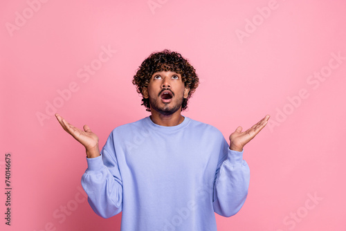 Photo of surprised cheerful man wear trendy clothes catch information news poster look up empty space isolated on pink color background