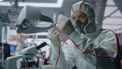 Chemistry expert researching virus in protective uniform at laboratory close up