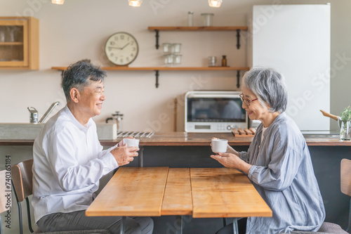 家のダイニング・カフェでお茶・コーヒーを飲むアジア人高齢者夫婦 