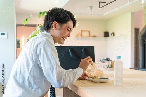 コンビニ・スーパーの弁当を食べるアジア人男性ビジネスマン（一人暮らし・独身・不健康・栄養バランス） 