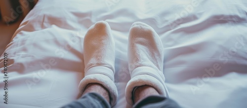 Cozy feet under white sheets in comfortable bed concept for relaxation and sleep
