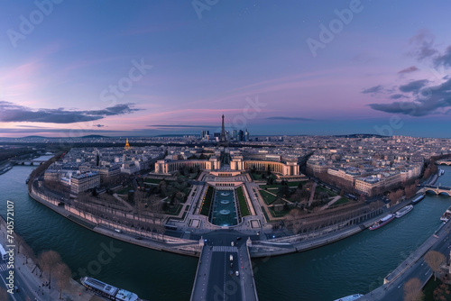 Evening drone view of Paris, city lights twinkling