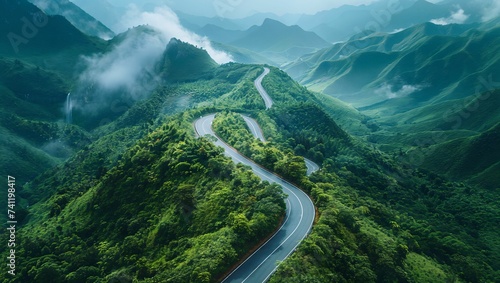 Aerial shot of a curved road on a green mountain in the rainy season