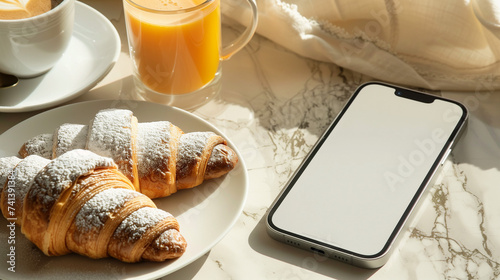 White Screen Smartphone Mockup on Marble Table with Morning Breakfast: Top View of Blank Screen Mobile Phone, Croissants, Coffee, and Orange Juice