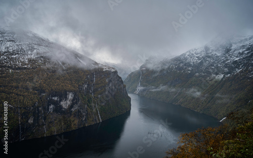 Panoramic image of the fjords of Norway in autumn, at sunset, with the Geiranger waterfalls.