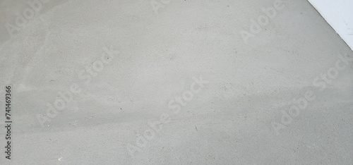 A newly completed cement floor or wall. Blank cement floor for adding text. The floor has slight roughness because it is not a polished cement floor. 