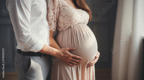 Man and woman holding pregnant bump expecting baby. Happy family hands on stomach closeup.