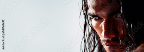 Intense gaze of a man with long wet hair. Concept of raw human emotion, men's power, sport, natural elements. Copy space