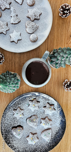 Handmade winter cookies with powder sugar. Christmas composition with hot chocolate. Flat lay.