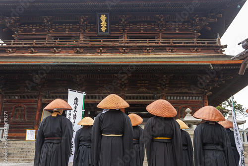 Nagano, Japan. Japanese Zen Buddhist monks of the Soto school with Kasa hats looking at the Sanmon Gate in Zenko-ji, a buddhist temple