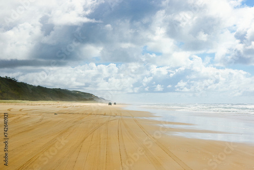 4-wheel drive pickups travelling on the sandy highway of the 75-mile beach on the east coast of Fraser Island, Queensland, Australia