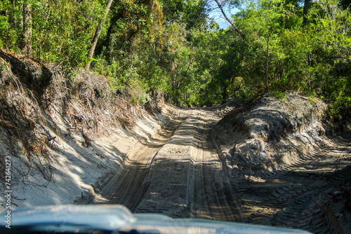 Wheel tracks on a sandy road in the Great Sandy National Park on Fraser Island, off the coast of Queensland in Australia - First person view of 4x4 driving in a rainforest