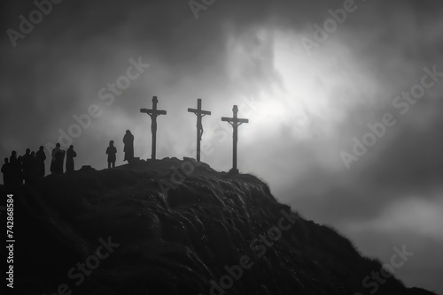 three crosses on top of hill stand against a darkening sky.