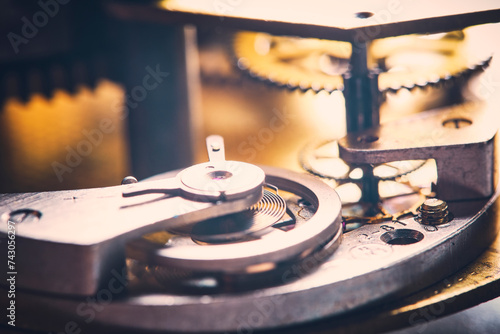 Details mechanism antique mechanical watch are illuminated contoured sunlight.