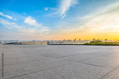 Empty square floor with city skyline at sunrise in Hangzhou