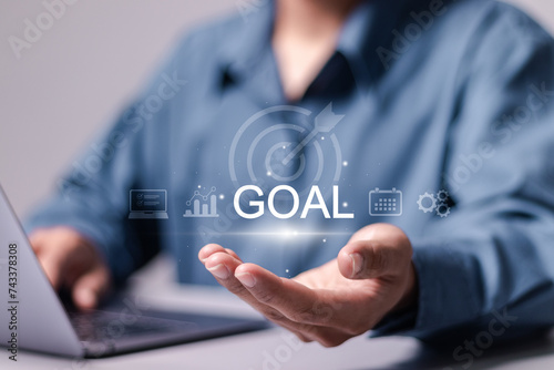 Goal concept. Achieving goals and objectives or goal setting. Businessman use laptop with goal icon on virtual screen.