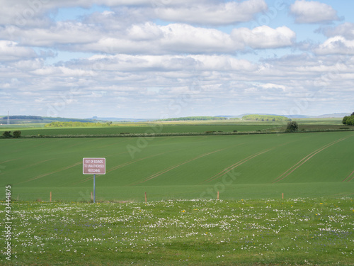 Red sign on open farmland stating out of bounds to unauthorised personnel indicating no public access or right of way